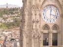 Clock tower with the Virgin on the Panecillo Hill in the distance.